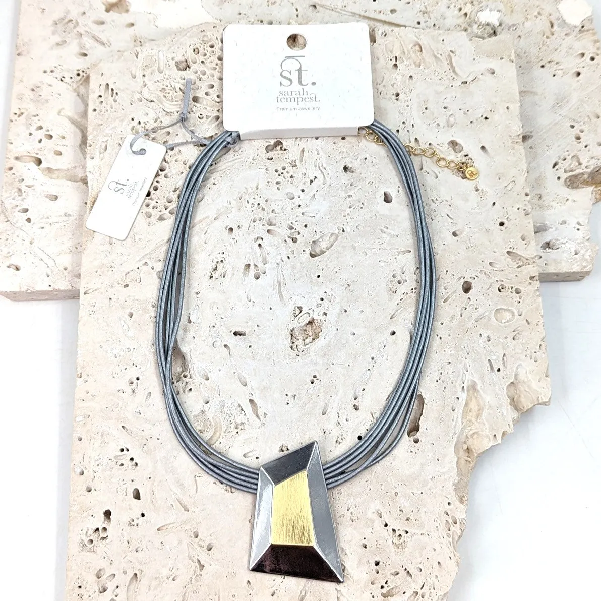 Geometric shape necklace with scratched surface element on multistrand leather